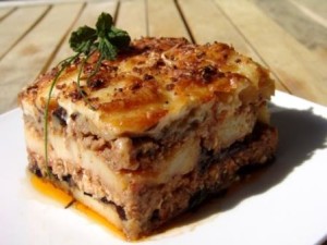 Una Moussaka qui preparata su tre strati con melanzane parzialmente sbucciate.