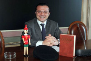 Cateno De Luca fattosi ritrarre qui fra la Bibbia e Pinocchio in una spiritopsa immagine, studia da sindaco di Messina e appoggia vigorosamente Musumeci