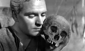Laurence Olvier in Amleto accosta alla guancia il teschio dell'amico Yorick, riflettendo sulla caducità delle vita: la finzione è meramente poetica. Yorick non poteva essere già un teschio. Ma Shakespeare giganteggia. Il grande monologo verrà nell'atto seguente...