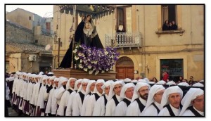 La drammatica apparizione della Madonna Addolorata trainata dagli "incappucciati" tra la folla commossa.