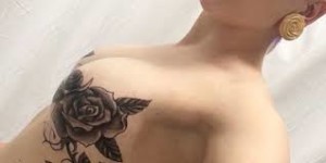 Tatuaggio sul petto di una giovane donna: "il mio corpo è un mazzo di rose..."