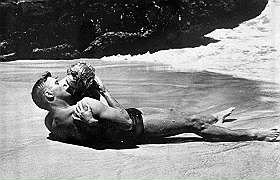 Sulla spiaggia il rude Burt e la eterea Deborah. Ma il bacio è appassionato, Passione e contrasto, quasi 'la bella e la bestia'. Ma L'attore divenuto anche Pricipe Salinas è stato anche un sex simbol, un divo per molte donne. Fu anche Oscar e tenne testa ad Anna Magnani che lo vinse ne La Rosa Tatuata.