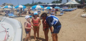 L'istruttore si piega per spiegare da vicino ai giovanissimi allievi i primi segreti della Vela.