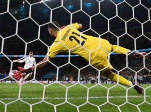 Prospettiva da dietro la rete. Donnarumma: la magica mano ch ferma la palla scagliata a Morata. Parare è il momento decisivo delle finali ai rigori. Segnarli - se così si puiò dire - è più ...facile.
